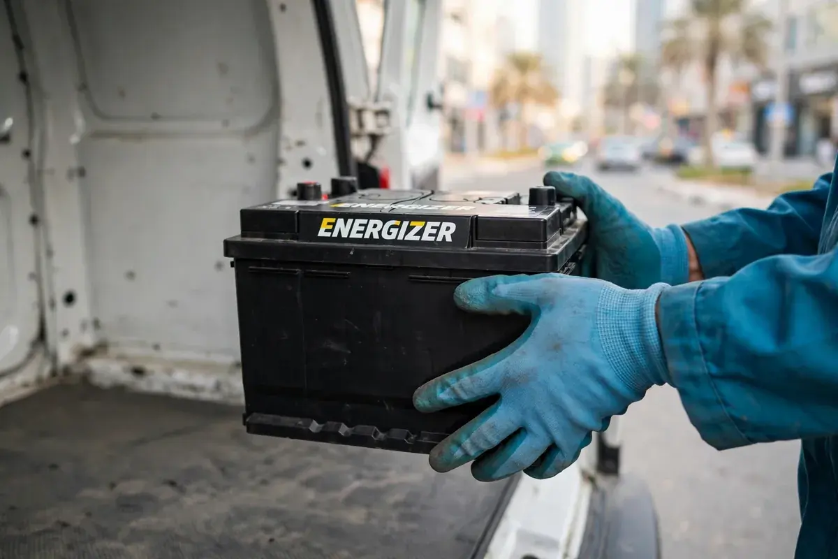 Technician carrying a new Energizer battery from the service van